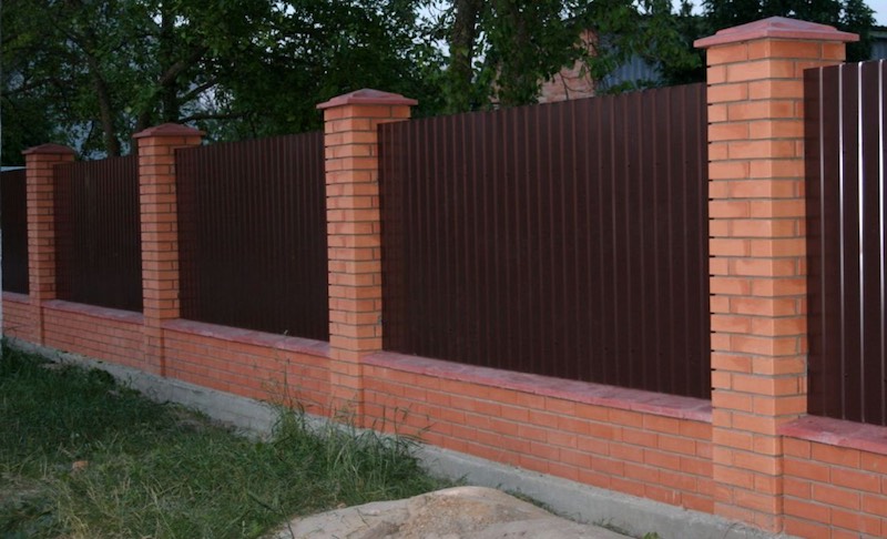 Забор из коричневого профнастила со столбами из кирпича